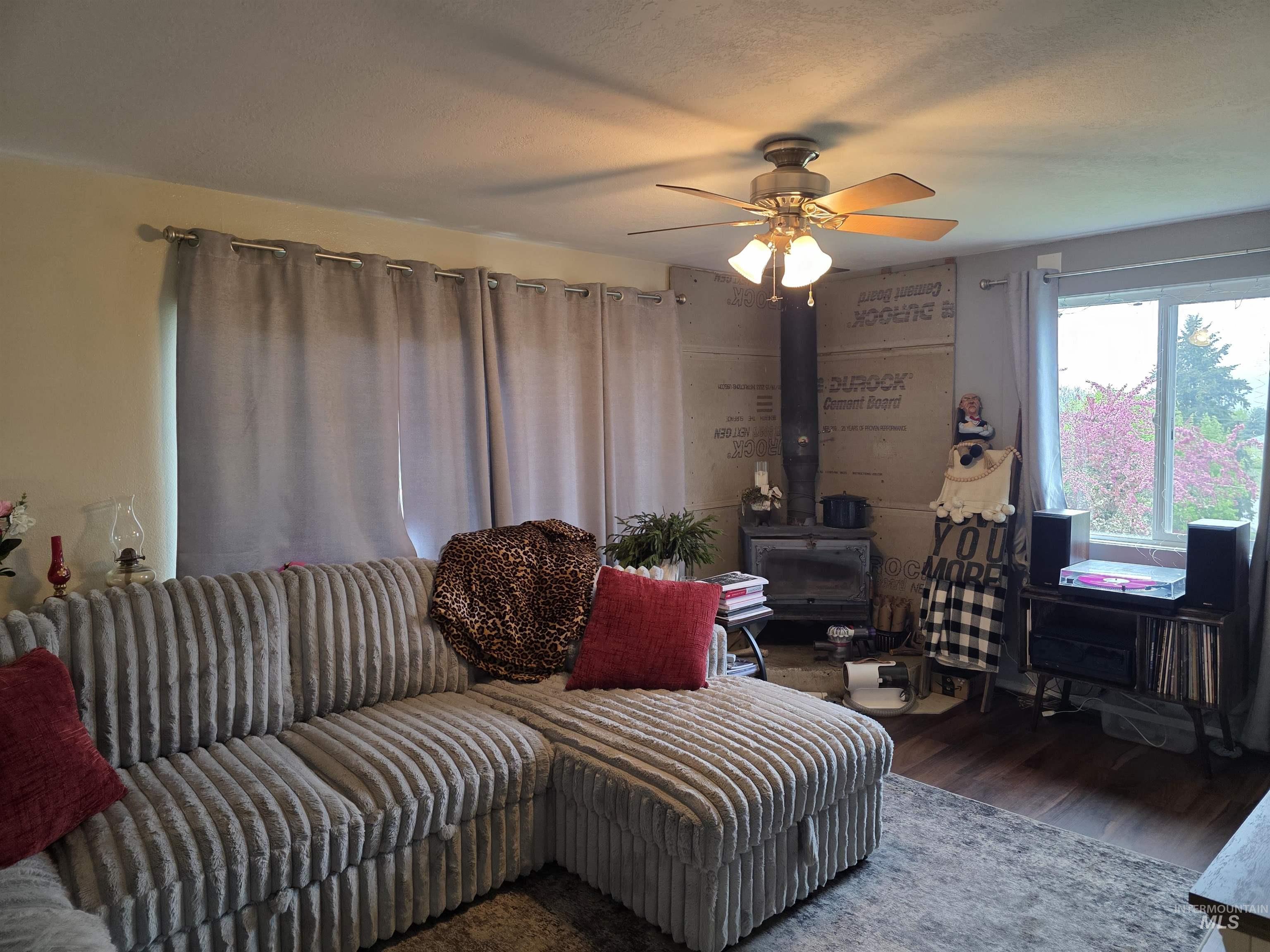 223 Larch Road Kamiah, ID 83536 - Photo 6 of 25 Living area featuring a ceiling fan, wood-look flooring, and a window with exterior tree views