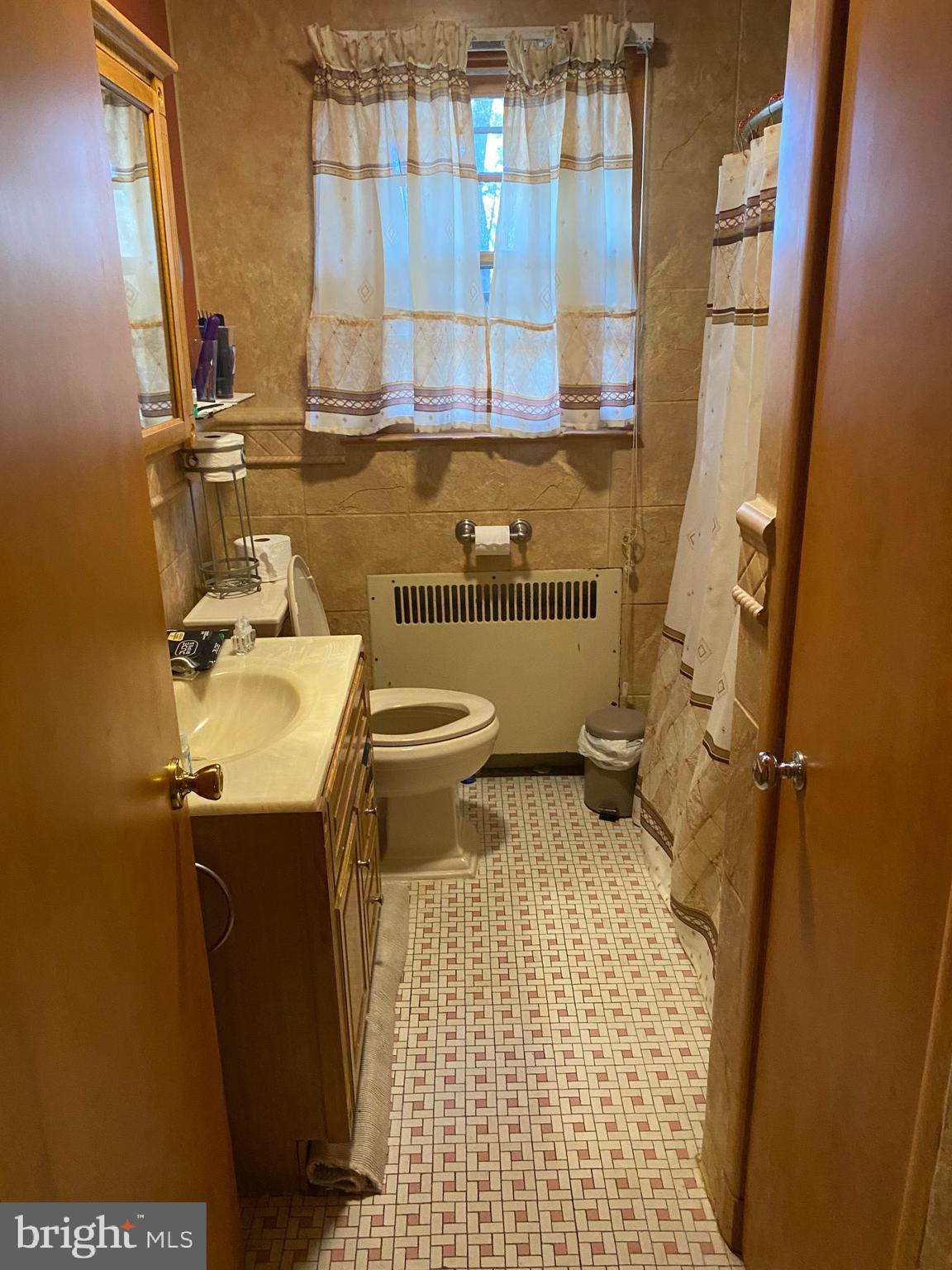 8305 Windsor Mill Road Baltimore, MD 21244 - Photo 13 of 15 a bathroom with a sink toilet and mirror