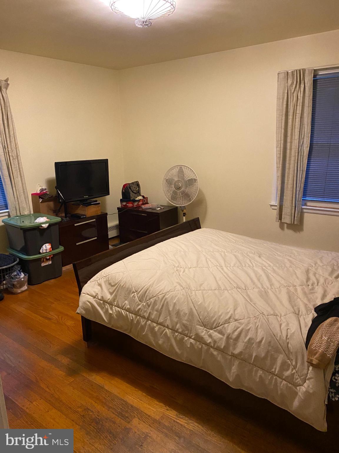 8305 Windsor Mill Road Baltimore, MD 21244 - Photo 7 of 15 a spacious bedroom with a bed and a television