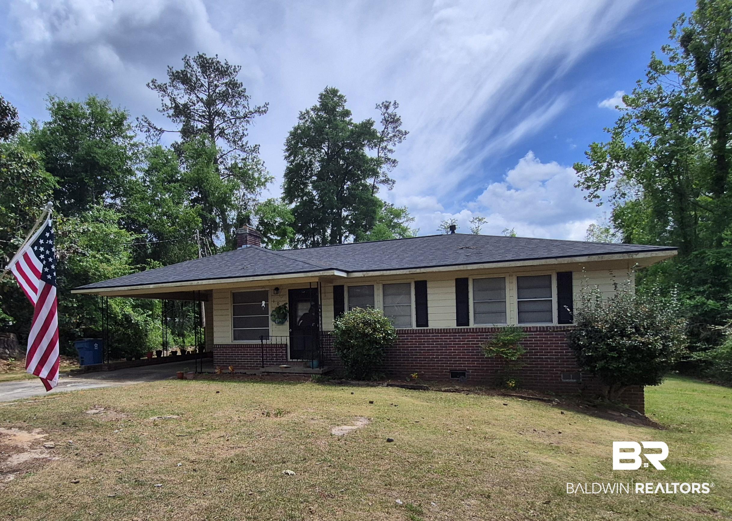 Ranch-style residence featuring a brick and siding exterior, a dark shingle roof, and a covered carport