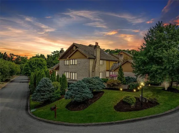 a view of a house with a yard and potted plants