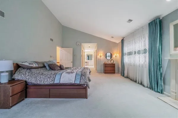 a spacious bedroom with a bed and a chandelier