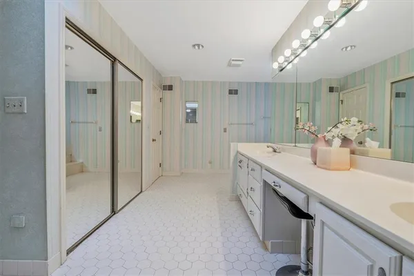 a room with a sink and a large mirror