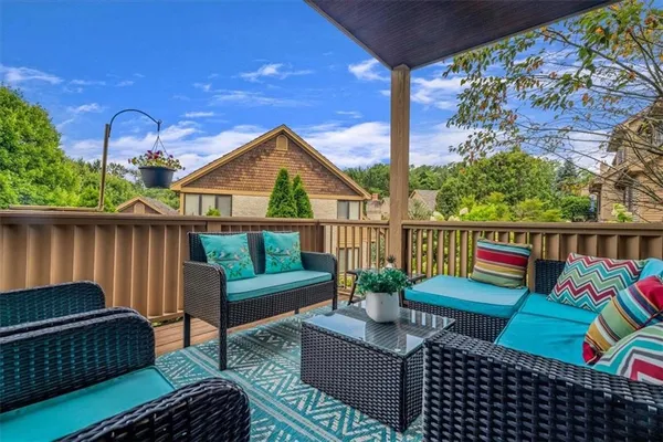 a roof deck with couches and wooden floor