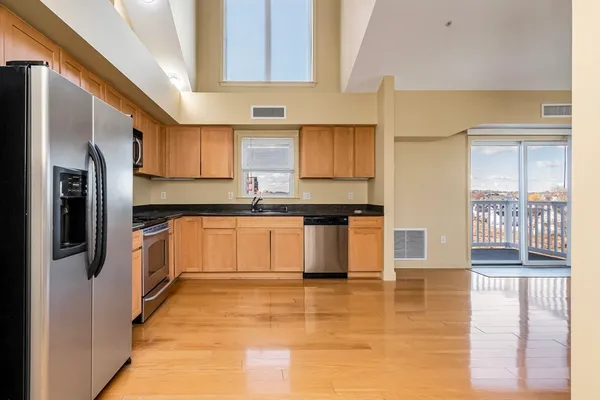 a kitchen with stainless steel appliances granite countertop a stove a sink and a refrigerator