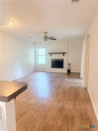 a view of an empty room with a fireplace and a window