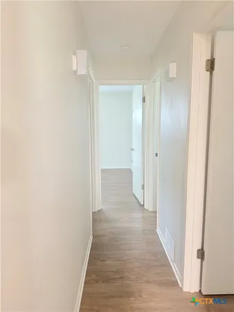 a view of a hallway with wooden floor