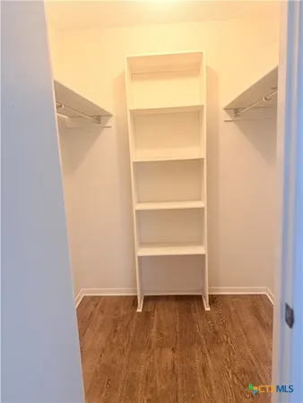 a view of an empty walk in closet with empty racks