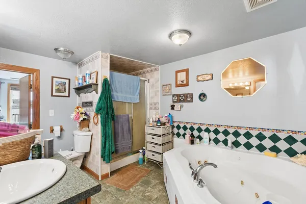 a bathroom with a tub sink and mirror