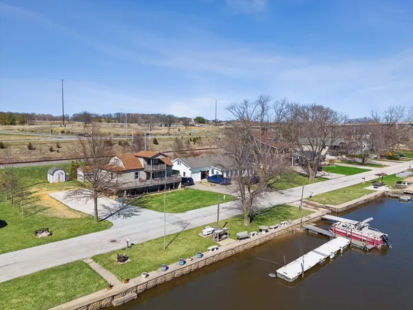 an aerial view of a house with a garden and lake view