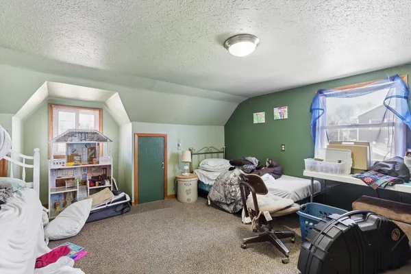 a room with lots of white furniture and a lamp