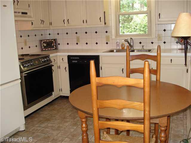 400 Grenham Road Greensboro, NC 27455 - Photo 7 of 15 Kitchen. The kitchen space has a tile backsplash and the dishwasher and refrigerator have been updated in recent time.