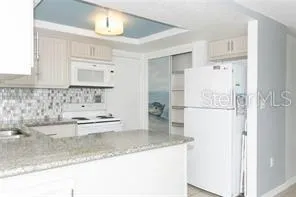 a kitchen with stainless steel appliances granite countertop a sink and a refrigerator