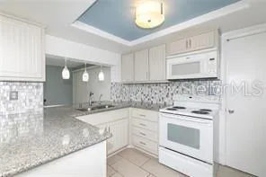 a kitchen with granite countertop a sink stove and cabinets