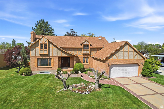 960 South 550 East Orem, UT 84097 - Photo 1 of 1 Tudor-style house featuring brick siding, concrete driveway, a front yard, a chimney, and a garage