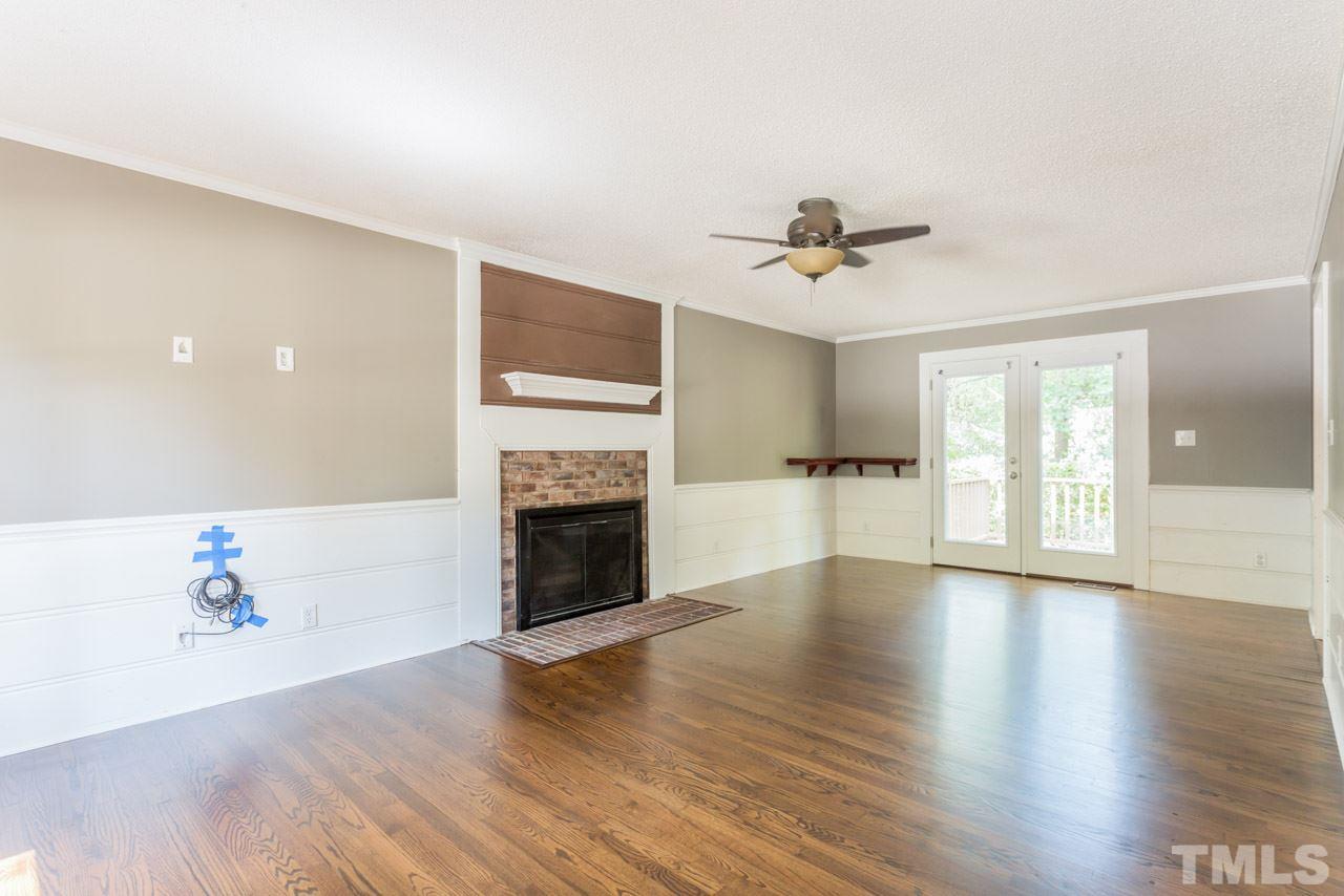 7308 Wilderness Road Raleigh, NC 27613 - Photo 12 of 25 a view of an empty room with a fireplace and a window