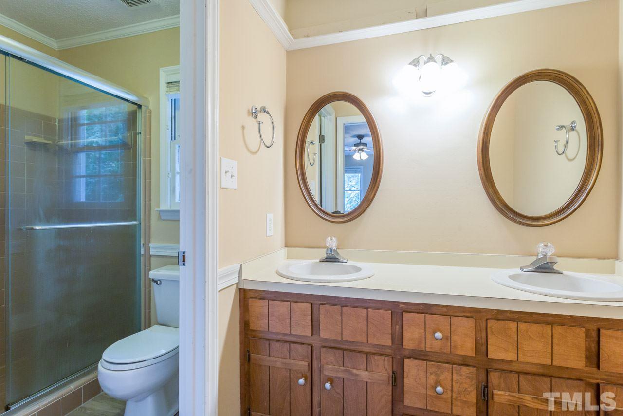 7308 Wilderness Road Raleigh, NC 27613 - Photo 18 of 25 a bathroom with a toilet a sink and a mirror