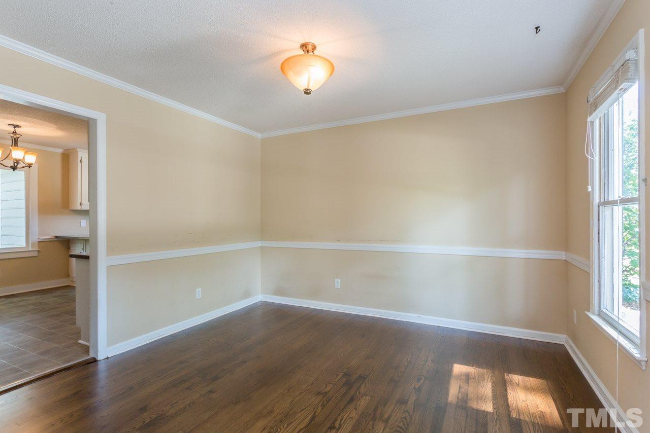 7308 Wilderness Road Raleigh, NC 27613 - Photo 3 of 25 an empty room with wooden floor and windows