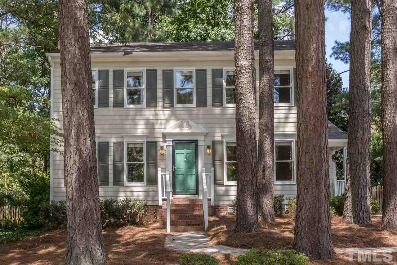 7308 Wilderness Road Raleigh, NC 27613 - Photo 25 of 25 a view of a brick house with large windows and large tree