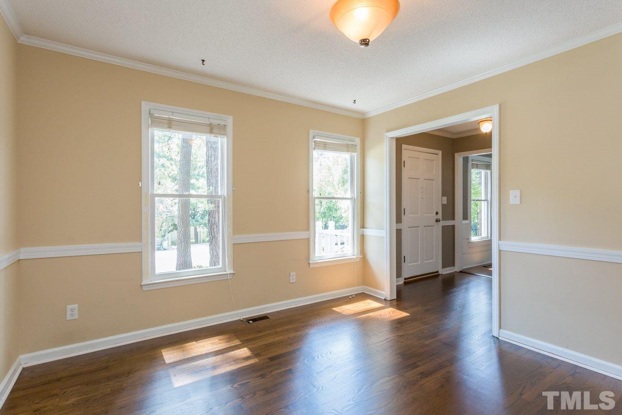 7308 Wilderness Road Raleigh, NC 27613 - Photo 4 of 25 a view of an empty room with wooden floor and a window