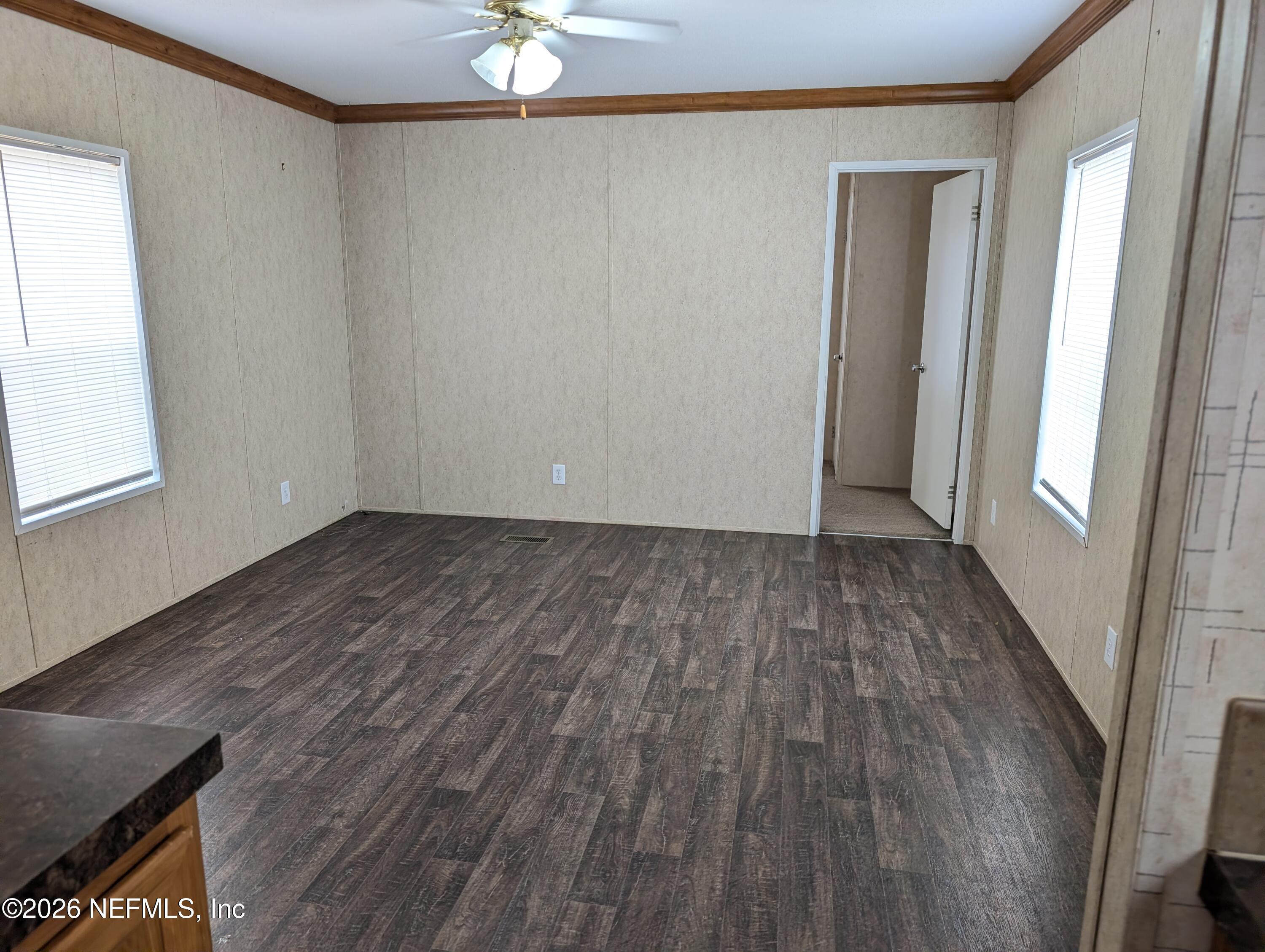 125 Hayman Drive Interlachen, FL 32148 - Photo 2 of 14 an empty room with wooden floor and windows