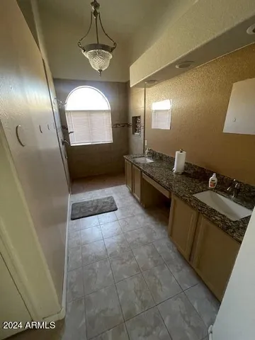 a view of hallway with stainless steel appliances a refrigerator and window