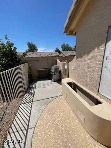 a view of a patio with table and chairs under an umbrella