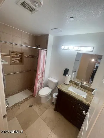 a spacious bedroom with a bed and a chandelier