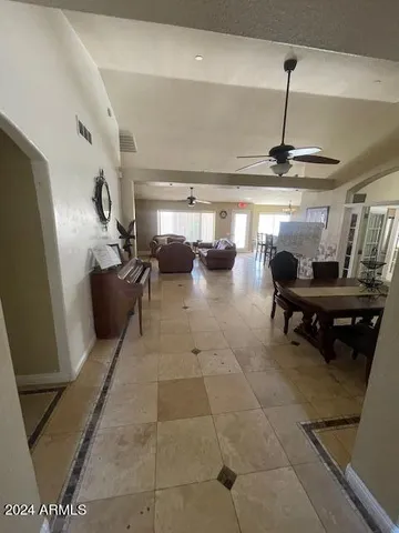 a living room with furniture a ceiling fan and a rug