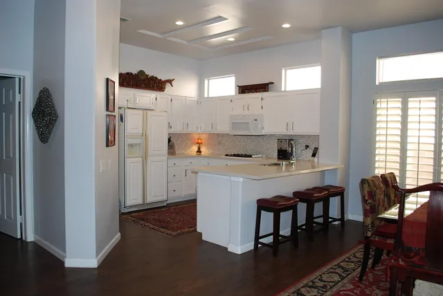 a kitchen with refrigerator and chairs