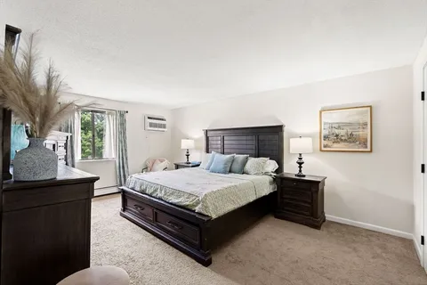 a bedroom with a bed lamp and a potted plant