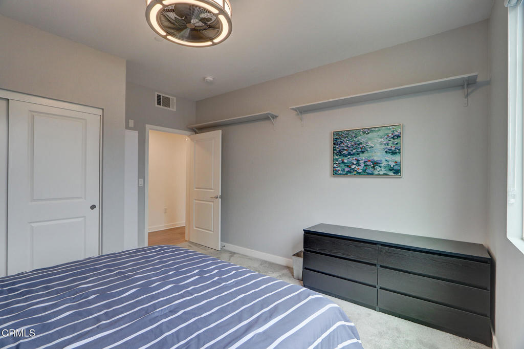 2810 Wagon Wheel Road, Unit 304 Oxnard, CA 93036 - Photo 20 of 35 a bedroom with a bed and a chandelier