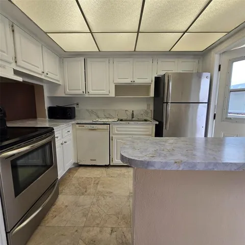 a kitchen with stainless steel appliances granite countertop a sink a stove a microwave and a refrigerator