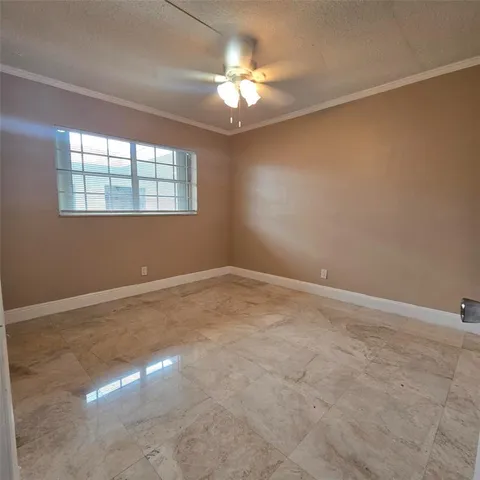 en empty room with windows and chandelier fan