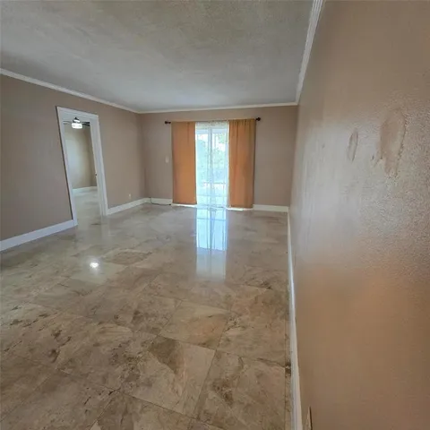 a view of an empty room with window and bathroom