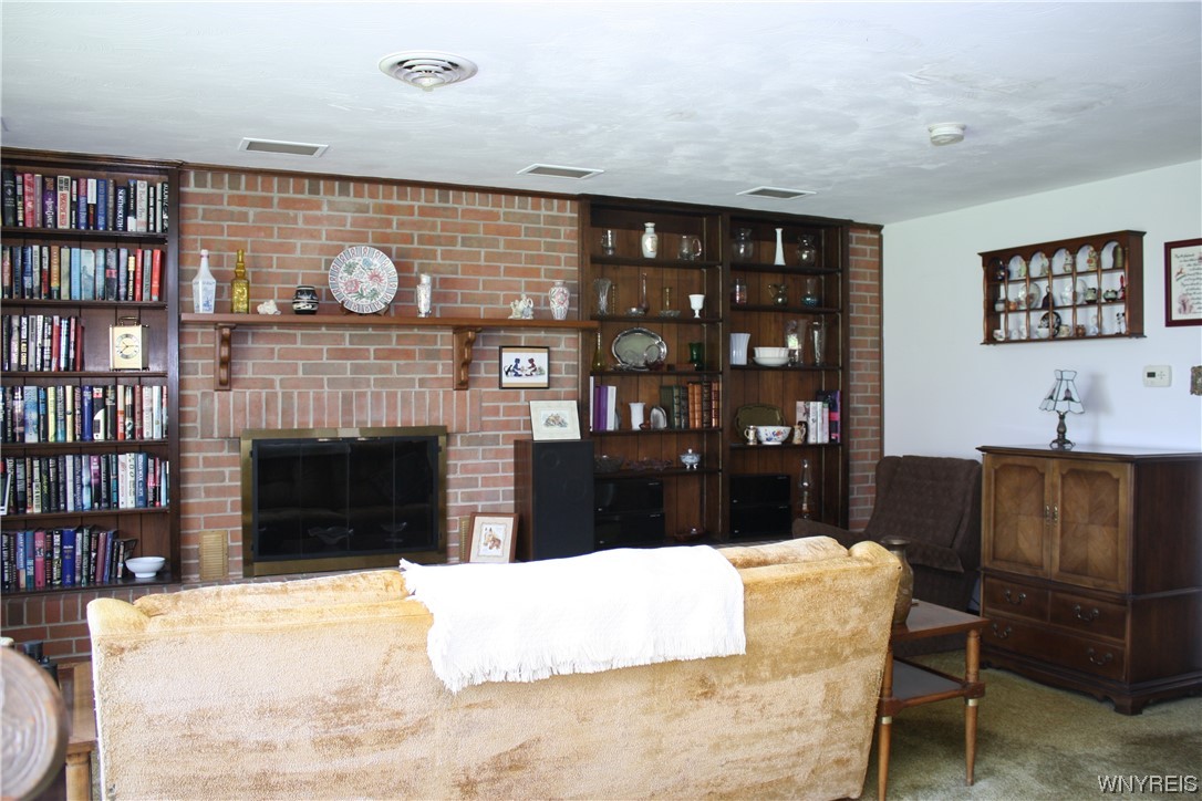 2831 Lower Mountain Road Lewiston, NY 14131 - Photo 6 of 44 Living Room with woodburning fireplace and bookcas