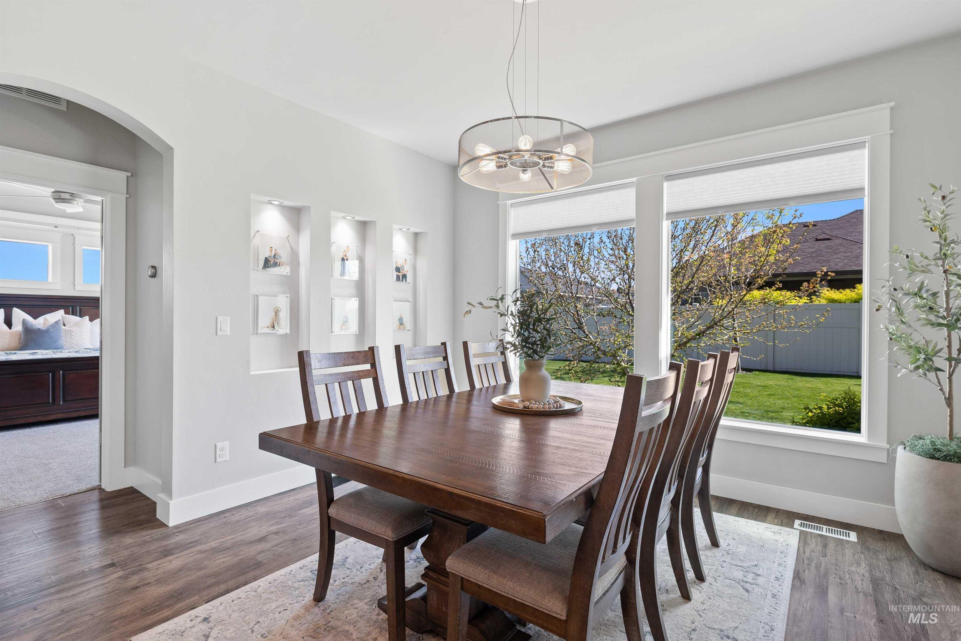 2441 Blick Lane Twin Falls, ID 83301 - Photo 13 of 50 Dining area featuring wood-finish flooring, a contemporary chandelier, and three lighted wall niches