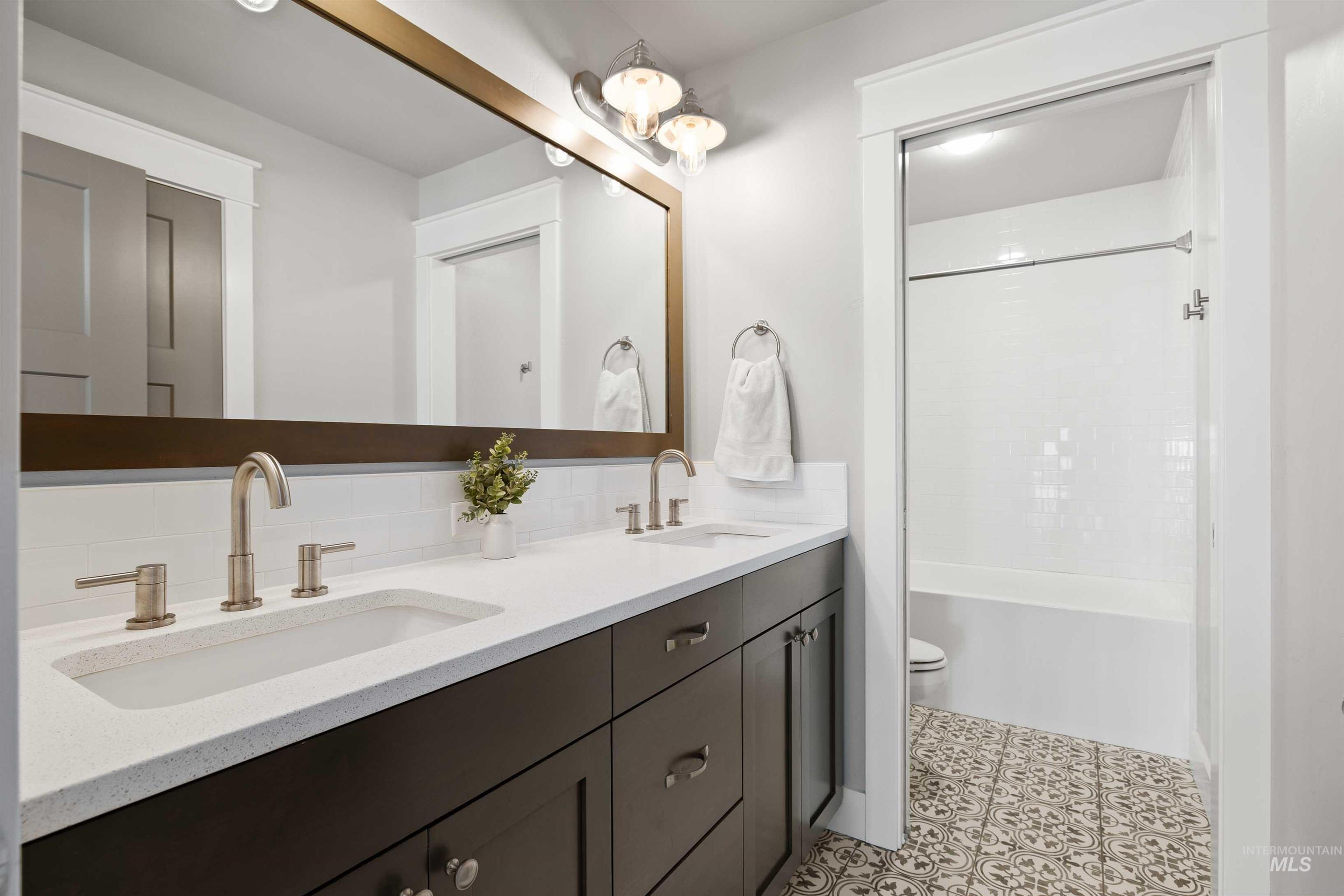 2441 Blick Lane Twin Falls, ID 83301 - Photo 25 of 50 Bathroom featuring double vanity, shower combination, and light tile patterned floors