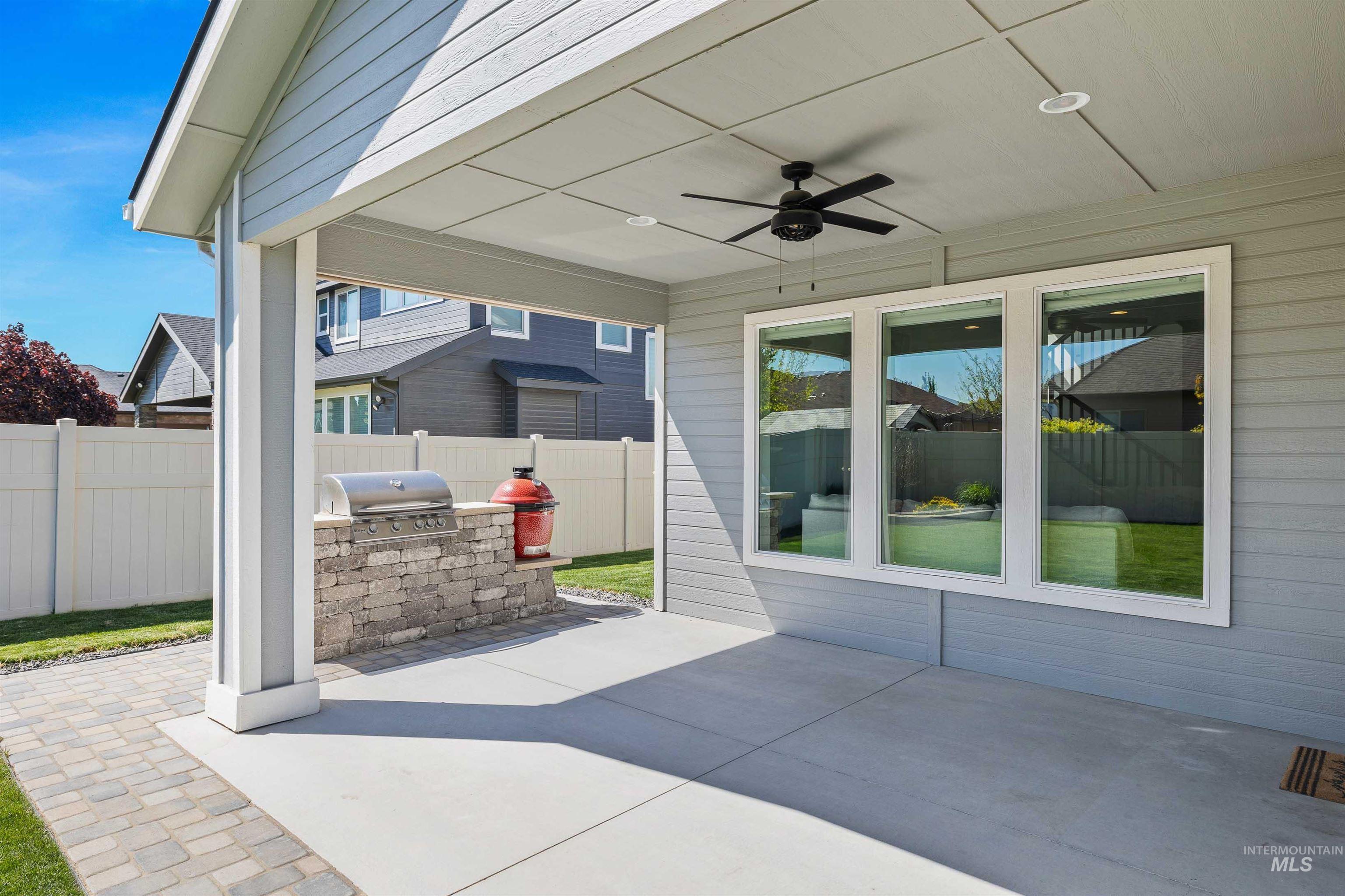 2441 Blick Lane Twin Falls, ID 83301 - Photo 38 of 50 Covered patio featuring an outdoor kitchen with a built-in stone grill station, concrete flooring, a ceiling fan, recessed lighting, and three large windows