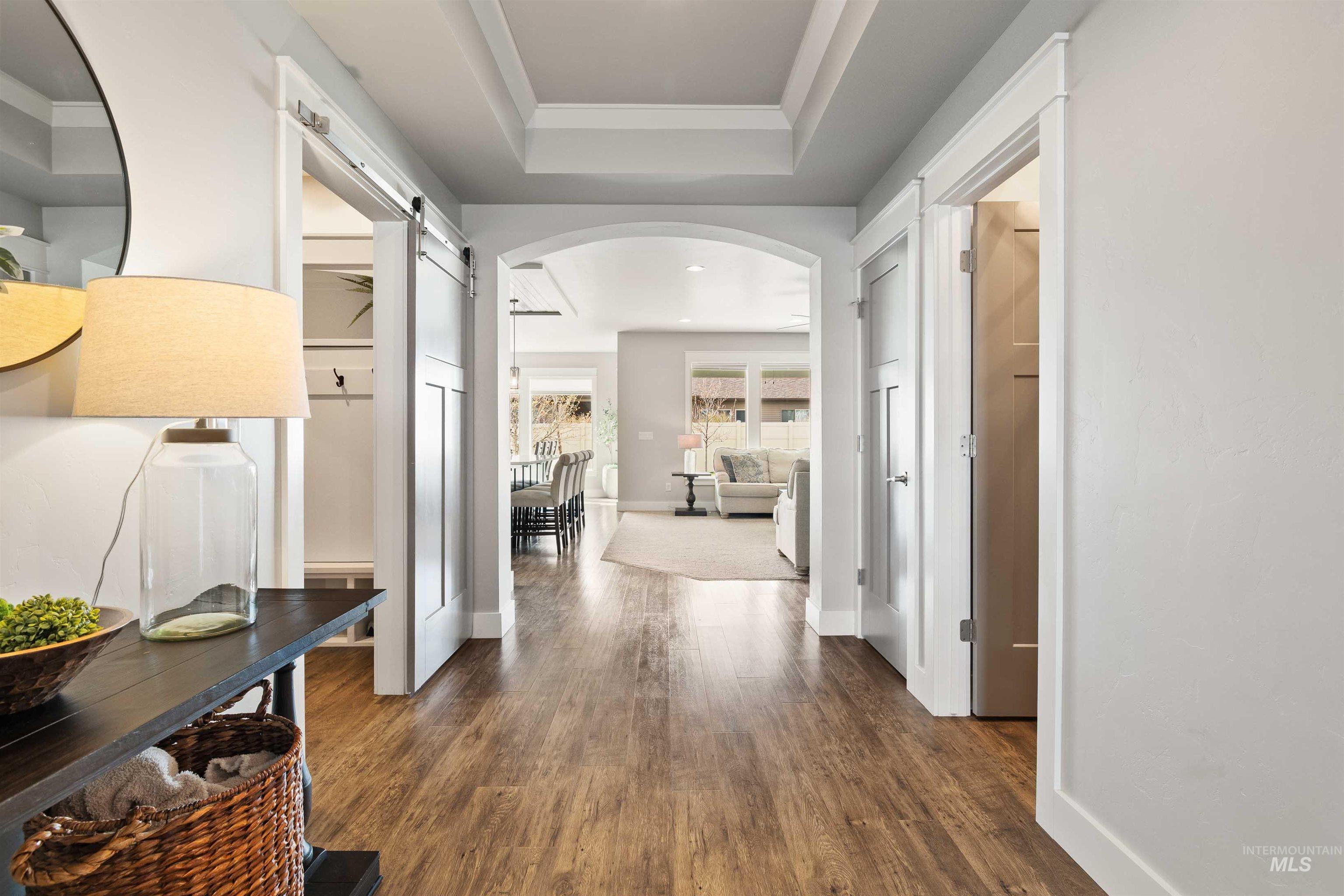 2441 Blick Lane Twin Falls, ID 83301 - Photo 4 of 50 Hallway featuring arched walkways, a barn door, dark wood-type flooring, a raised ceiling, and recessed lighting