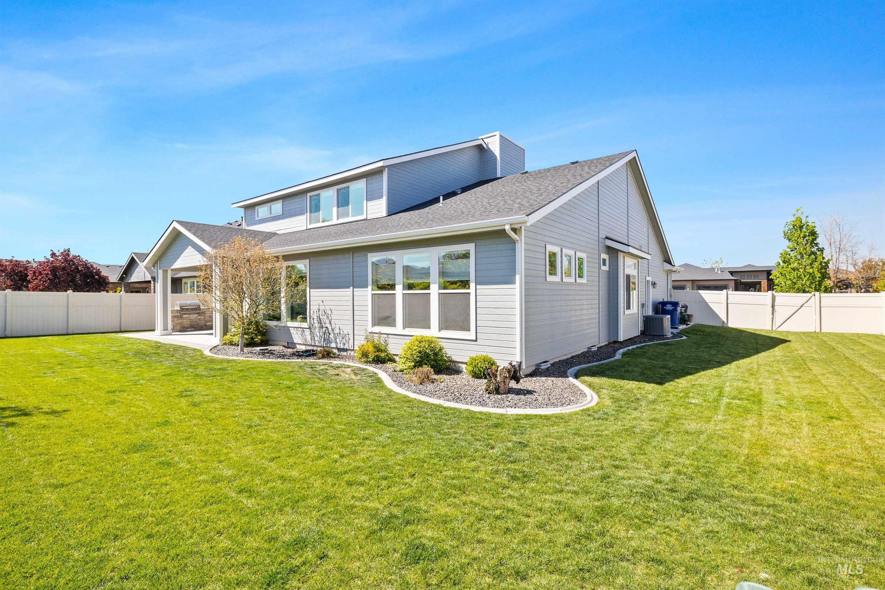 2441 Blick Lane Twin Falls, ID 83301 - Photo 41 of 50 Spacious rear yard with a manicured lawn, modern gray siding, white window trim, a covered patio area, and perimeter fencing