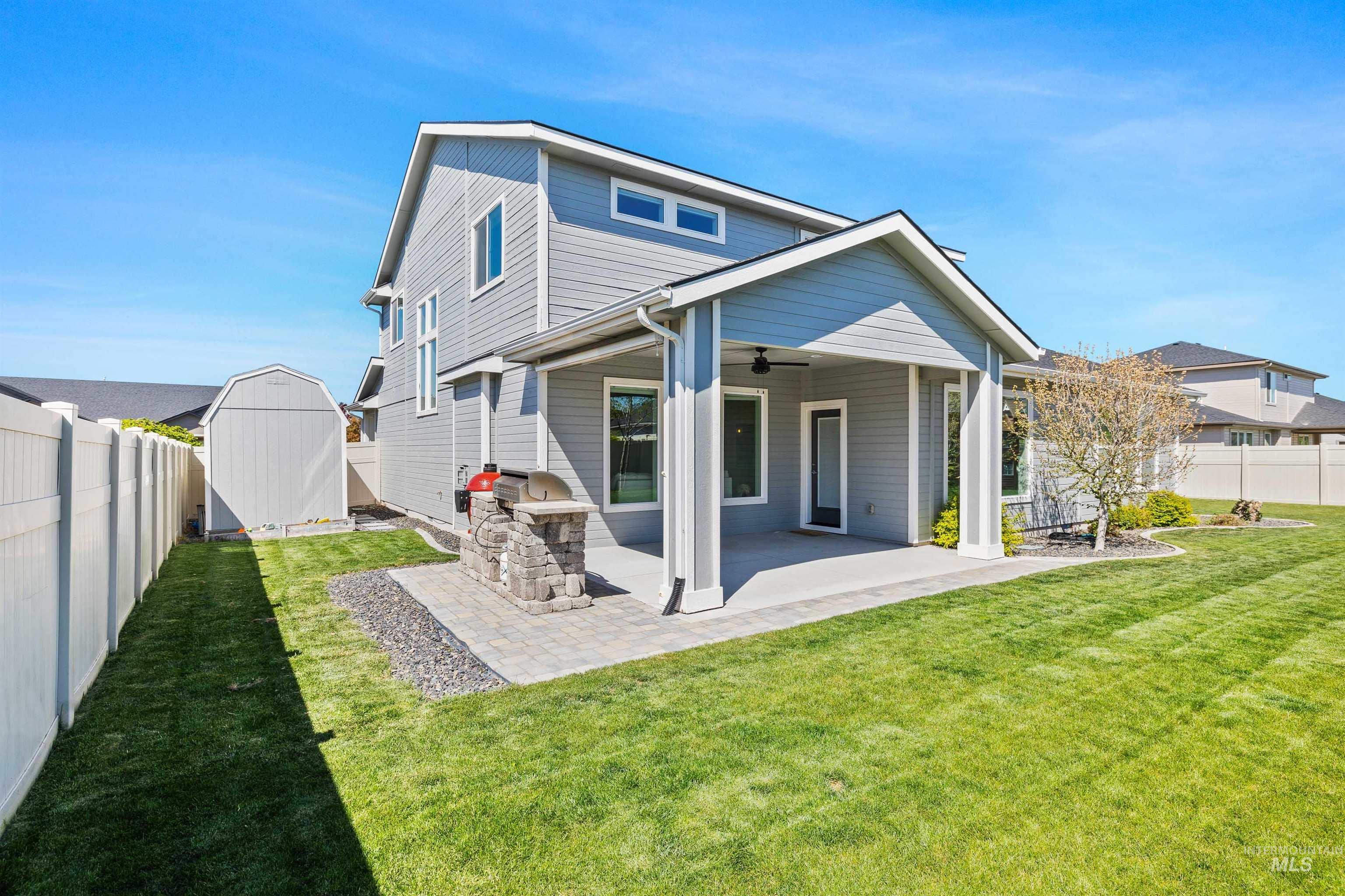 2441 Blick Lane Twin Falls, ID 83301 - Photo 42 of 50 Expansive backyard featuring a covered patio, built-in outdoor grill station with stone accents, a detached storage shed, and a manicured lawn