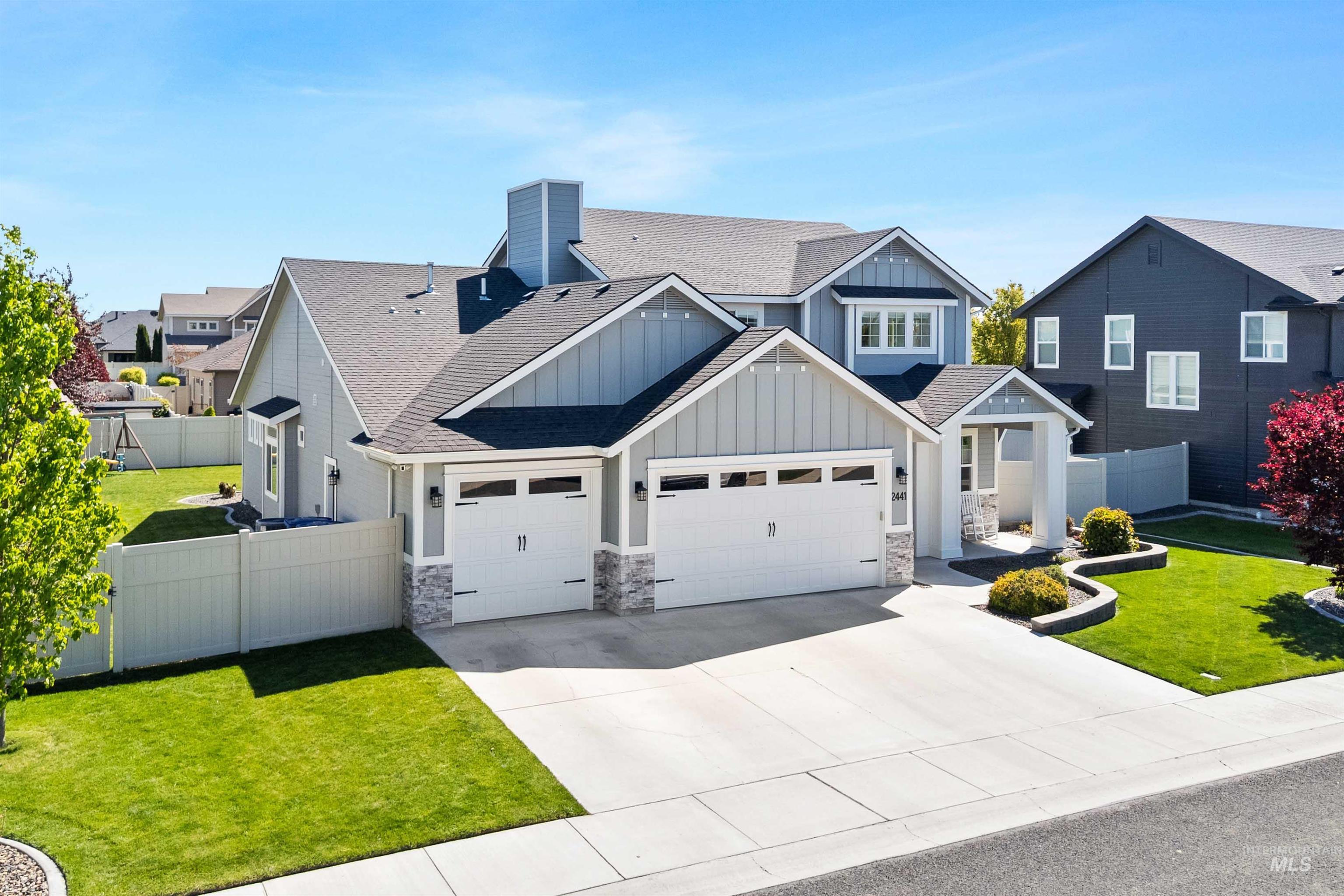 2441 Blick Lane Twin Falls, ID 83301 - Photo 44 of 50 Contemporary home featuring light grey siding with vertical accents, a dark shingle roof, and a two-car garage with transom windows