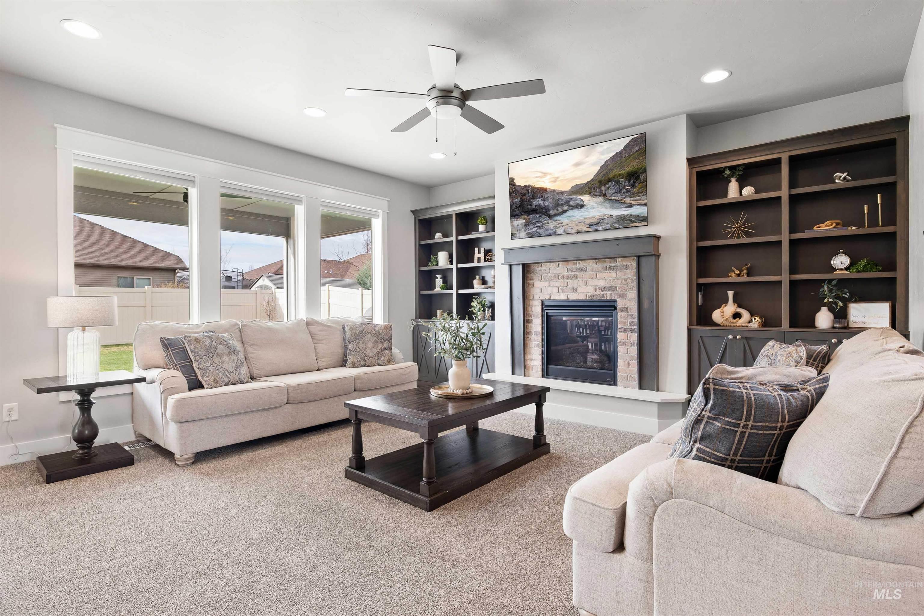 2441 Blick Lane Twin Falls, ID 83301 - Photo 5 of 50 Living area with a brick fireplace, carpet, a ceiling fan, built in shelves, and recessed lighting