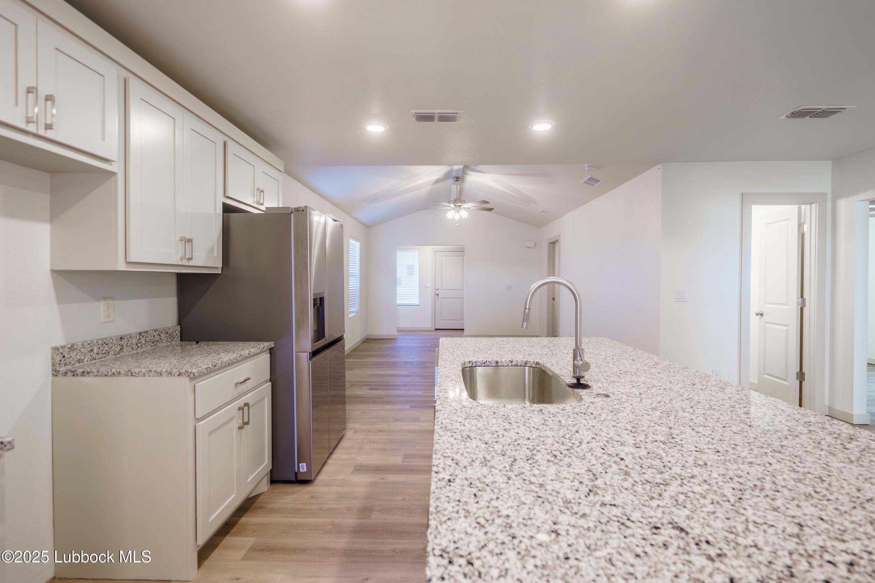 8006 Elm Avenue Lubbock, TX 79404 - Photo 3 of 12 a kitchen with stainless steel appliances granite countertop a refrigerator a stove and a sink