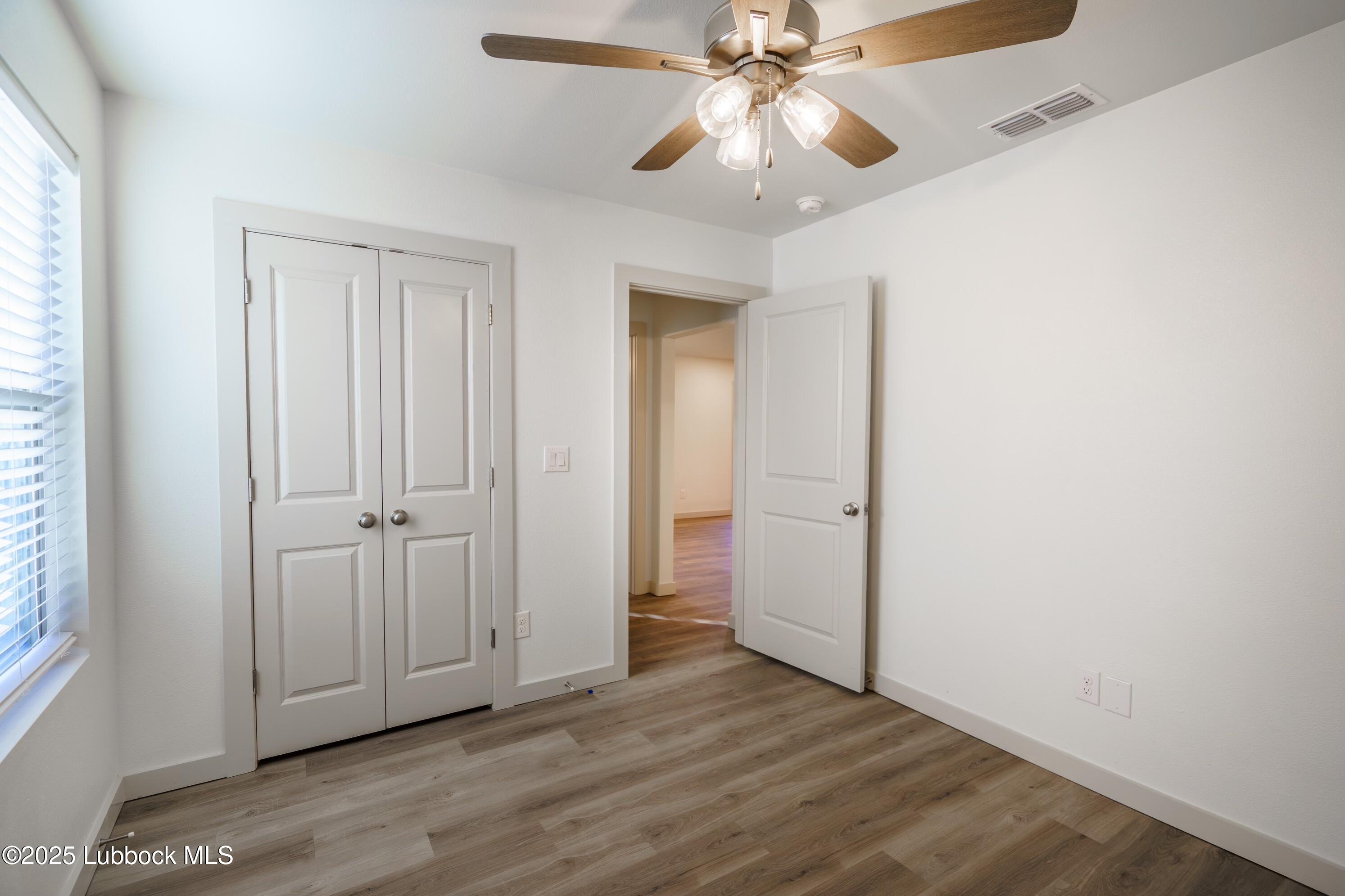 8006 Elm Avenue Lubbock, TX 79404 - Photo 9 of 12 an empty room with wooden floor closet and windows