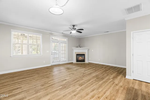 an empty room with fan and windows