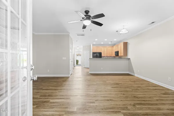a view of a kitchen with a sink and dishwasher with wooden floor