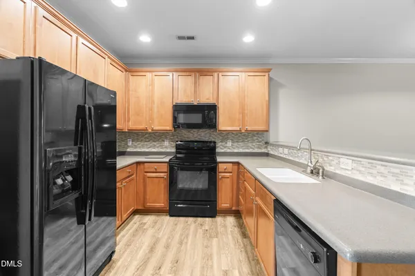 a kitchen with stainless steel appliances granite countertop a refrigerator a sink a stove a microwave and island