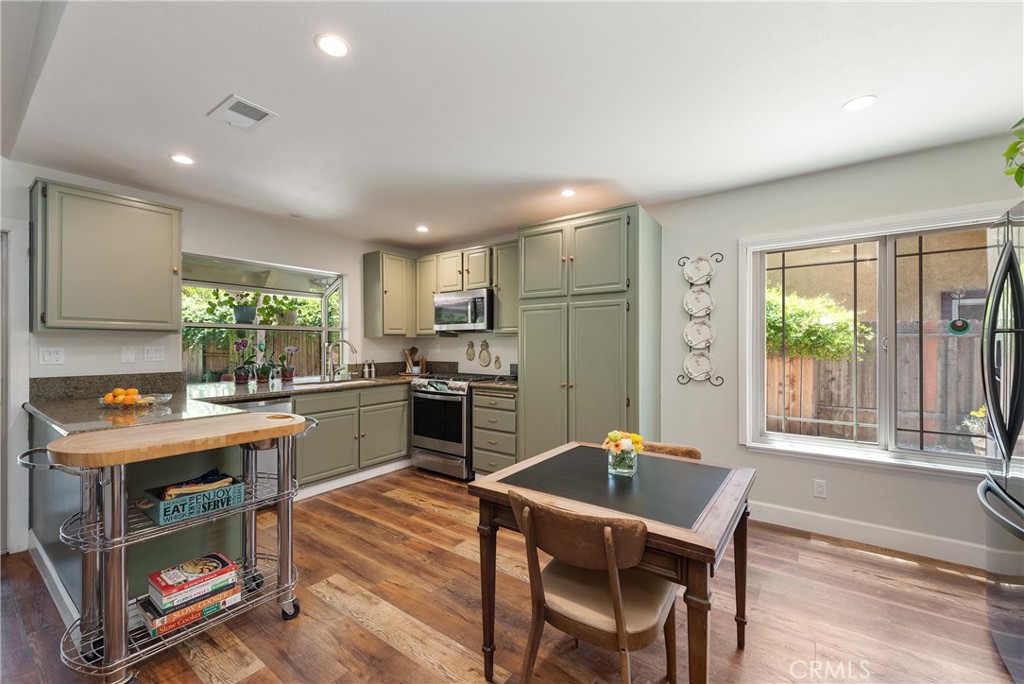 4384 Mill Valley Road Moorpark, CA 93021 - Photo 11 of 32 a kitchen with a table chairs refrigerator and microwave